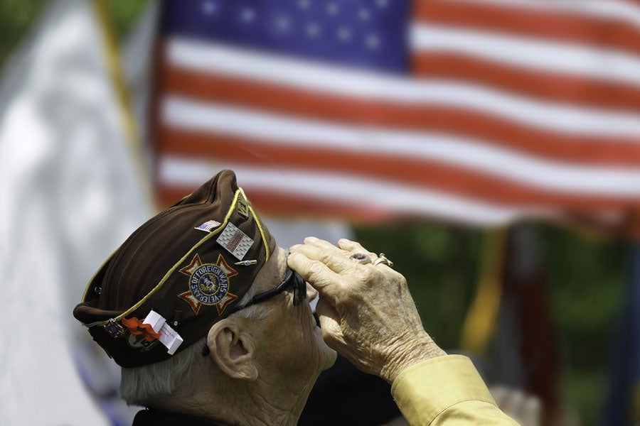 An old Military person saluting the U.S. flag